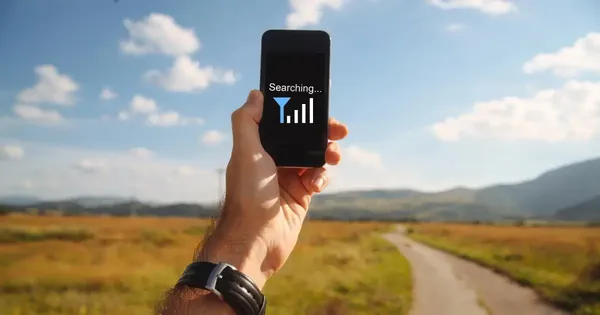 Người dùng đang sử dụng điện thoại ngoài trời, nhấn mạnh tầm quan trọng của việc có sóng ổn định để quá trình tải và ghép nhạc vô Vina Video diễn ra không gián đoạn.