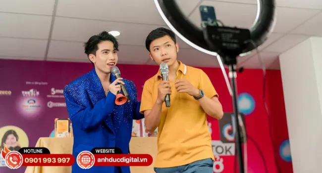 Một người dẫn chương trình nữ đang livestream trên Youtube với thái độ thân thiện, tươi cười, thể hiện kỹ năng giao tiếp tốt, một yếu tố quan trọng để tăng người xem live stream Youtube.