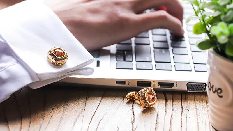 Người đàn ông diện áo sơ mi trắng kết hợp khuy măng sét đen lịch lãm, tạo điểm nhấn tinh tế