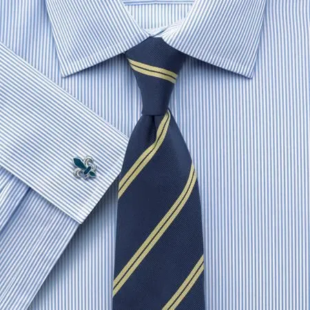 Người đàn ông mặc sơ mi xanh cùng khuy măng sét bạc, tạo vẻ ngoài hài hòa và chuyên nghiệp